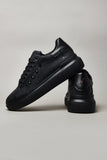 Black high sole sneakers with studs and paint splashes